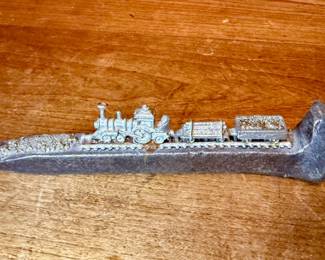Miniature pewter train on a railroad spike