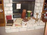 L. to r.  vintage yearbooks including a tribute book of townspeople who served in WWII, a pair of WWI calvary boots, a majolica vase and a pair of brass andirons