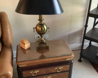 End table trimmed with black, paired with brass lamp and black shade.
