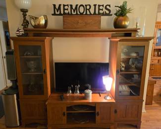 4 piece entertainment center with cabinets and covered shelves with glass doors.
