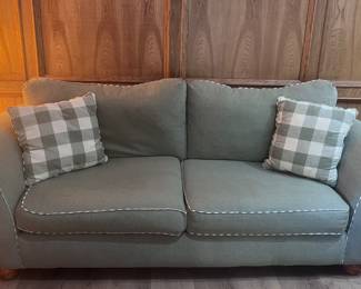 Green cloth couch with pillows