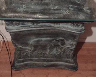 accent table, featuring a base with an elephant motif and a glass top