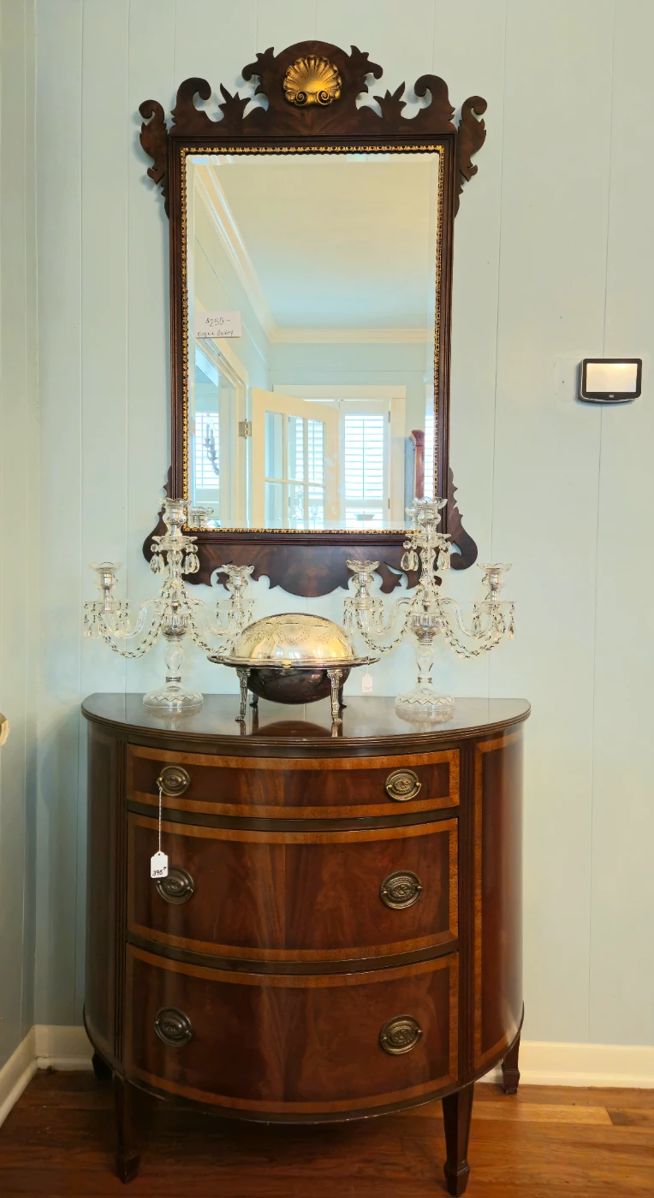 Mirror by Virginia Gallery. Pair of crystal candelabra. Roll top bacon or roll server. One of a pair of demilune chests.