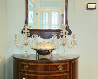Mirror by Virginia Gallery. Pair of crystal candelabra. Roll top bacon or roll server. One of a pair of demilune chests.