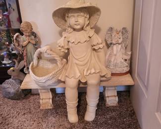 Garden statue of a girl sitting on a bench holding a basket