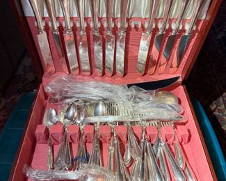 Silver-plated flatware set in storage chest with complete service for twelve.