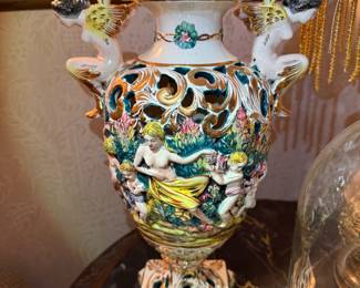 Capodimonte-Style Porcelain Urn
Large ornate Italian-style porcelain urn with intricate open-scroll design and full-relief cherub and maiden figures among flowers. Beautifully hand-painted in rich pastel tones with gilt accents—classic Capodimonte-style artistry and an elegant statement display piece.