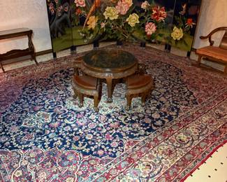Large Persian-style area rug with intricate floral medallion design in navy, red, and ivory tones.
