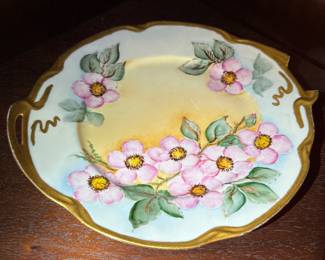 Hand-Painted Porcelain Plate with Pink Blossoms
Lovely vintage hand-painted floral plate with gold trim and soft pastel tones. Excellent decorative display piece.