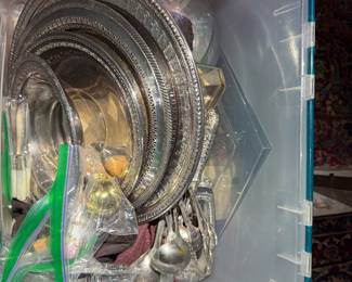 Bin of assorted silver-plated serving trays, bowls, and flatware.