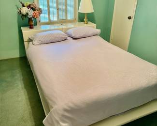 Platform bed with lighting below and cabinet behind