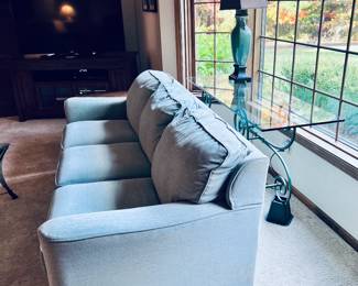 Living room furniture including matching light blue loveseat and sofa. Glass top Sofa table