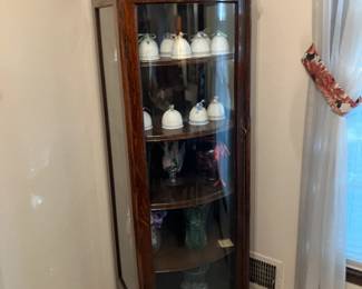 Tall narrow oak china cabinet with curved-glass door