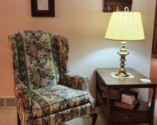 Lovely floral wing back chair with MCM end table to match coffee table, brass lamp, collector's cabinet with figurines, decor