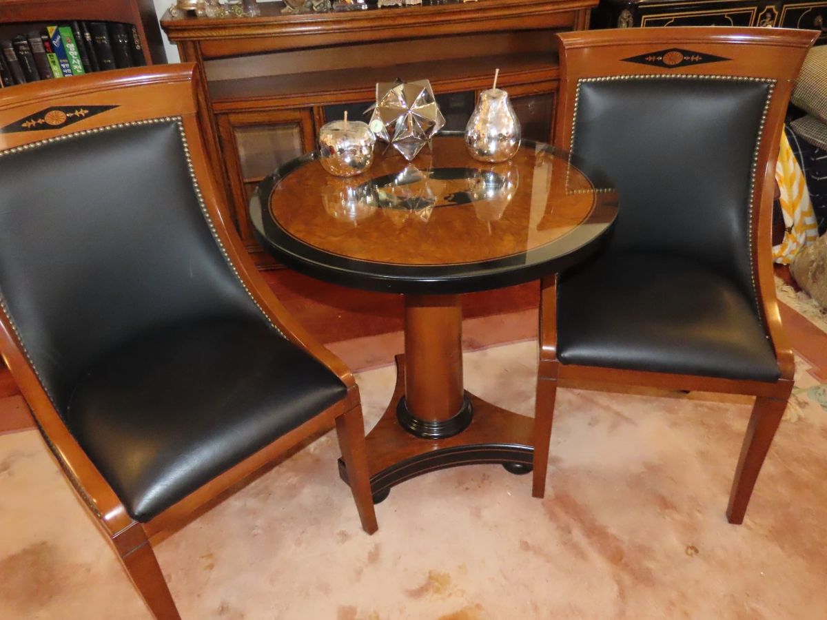 Pedestal table with glass over wood and two matching side chairs.