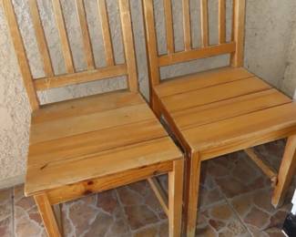 Two matching bare pine kitchen chairs.