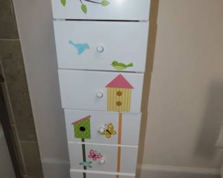Cute whimsical tall chest decorated with birds and bird houses.
