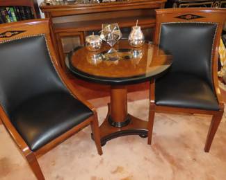 Pedestal table with glass over wood and two matching side chairs.
