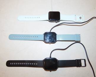 Three Apple watches and chargers.