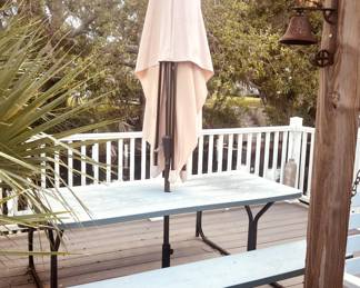 outdoor picnic table with benches and a center hole for an umbrella.