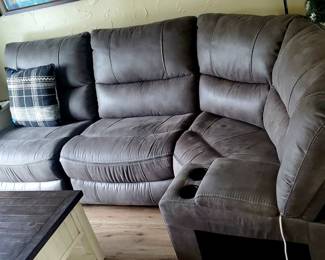  stone gray faux leather sectional sofa with a center console and recliners