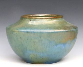 An early 20th century Pewabic Art Pottery vase. Low bulbous form with tapered shoulder and Iridescent glaze in mottled shades of Blue, Green and Gold. Impressed "Pewabic Detroit" mark. Minor surface wear and crazing. 7" diameter x 4 1/2" high.