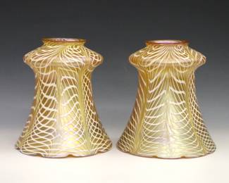 A pair of early 20th century Quezal Art Glass shades. Floriform with Iridescent Gold finish and White pulled linear decoration. Signed "Quezal" at fitters. Minor surface wear. Each 5 1/2" high with 2 1/8" fitters.