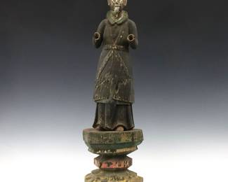 A 19th Century Spanish Colonial Santos figure. Carved wooden figure with polychrome decoration, depicting a male saint atop a carved wood plinth. Wear, some damage, shrinkage, lacks hands and part of a foot. 27 5/8" high overall.