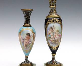 Two turn of the century French Sevres style garniture vases. Porcelain bodies with baluster form having hand-enameled scenes depicting lounging Cherubs on Champleve Bronze mounts with incorporated Onyx bases. Both artist signed, taller "V. Beis" and shorter "C. Rochette" for Claire Maglin Rochette. Minor wear to decoration, some flakes to Onyx, smaller foot plate slightly askew. Up to 9 1/2" high.