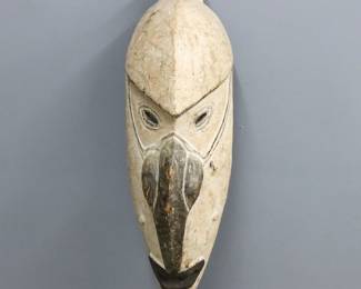 A large Papua New Guinea ceremonial mask. Carved wooden mask with monochrome decoration, features angled eyes of a hooked nose and pierced mouth. Some wear to decoration, minor damage. 40 1/2" high.