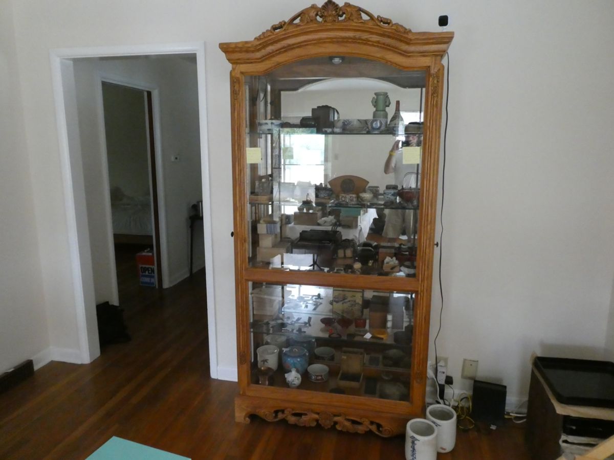 Solid carved oak display case with four thick glass shelves, glass back, and lamp.