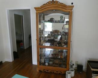 Solid carved oak display case with four thick glass shelves, glass back, and lamp.