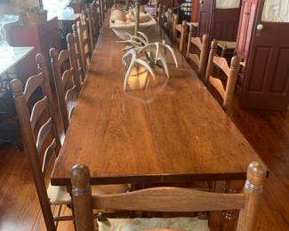Old growth cypress boarding house dining table with early cow hide chairs.  Table is 17 1/2 foot long (the stories this table could tell)