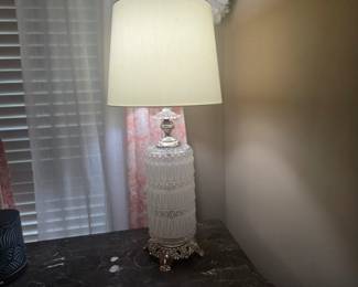 Beautiful white glass and brass-style table lamp with ornate base and neutral shade. Classic design with vintage charm, in excellent working condition. Approx. 32” H.