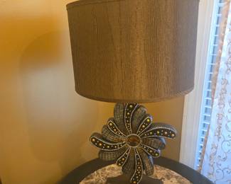 Unique lamp with beaded floral base design and brown textured shade. Elegant statement piece for a living room or study.