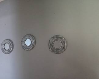 Set of three decorative round mirrors with ridged silver frames. Modern design, perfect for accent walls.