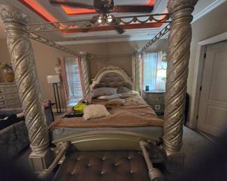 King Canopy Bed – Four-poster design with spiral-carved columns, tufted upholstered headboard, and ornate crown molding. Approx. 86” H x 82” W x 88” L.