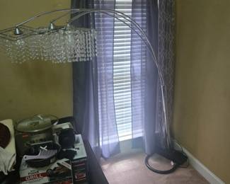 Contemporary arched floor lamp with chrome finish and cascading crystal-style shade. Adjustable arm design provides elegant illumination. Approx. 7 ft tall.