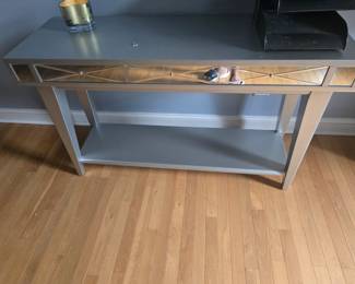 Elegant silver console table with mirrored trim and drawer detail. Perfect for entryway or living room décor