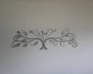 Beautiful silver metal wall sculpture featuring a branching leaf motif. Adds a stylish touch to any room.