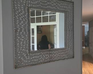 Large square mirror with a unique woven metal-style frame. Eye-catching piece for hallway, living, or dining area.