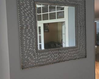 Large square mirror with a unique woven metal-style frame. Eye-catching piece for hallway, living, or dining area.