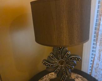 Unique lamp with beaded floral base design and brown textured shade. Elegant statement piece for a living room or study.