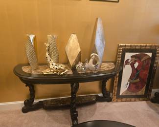 Black and marble-top console table with ornate carved legs.