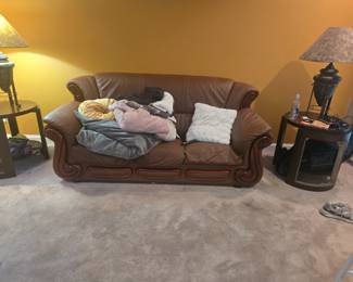Three-seat leather sofa completing the matching set. Features ornate wood trim and soft, full cushions. Approx. 85” W x 38” H x 38” D.
