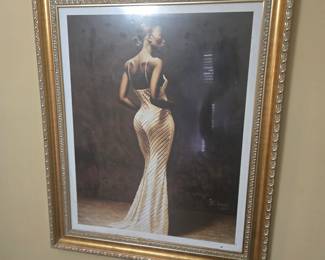 Elegant framed print by artist J.C. Bakari, dated 2001. Features a graceful woman in a gold gown, captured in a classic pose. Signed by the artist. Approx. 28” x 38”.