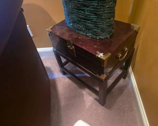 Compact dark wood side table with brass corner accents and drawer handle. Ideal for lamp or decorative display. Approx. 22"H x 18"W x 18"D.
