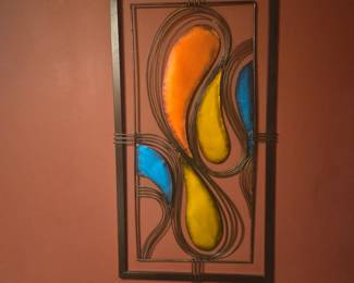 Metal wall art with flowing geometric design and rich stained glass accents in amber, blue, and orange. Measures approx. 26"H x 14"W.