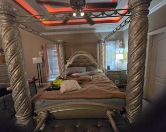 King Canopy Bed – Four-poster design with spiral-carved columns, tufted upholstered headboard, and ornate crown molding. Approx. 86” H x 82” W x 88” L.