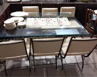 glass top dining table with wrought iron and leather chairs